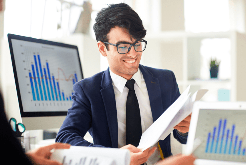 employee from accounting firm holding paper with screens with graph
